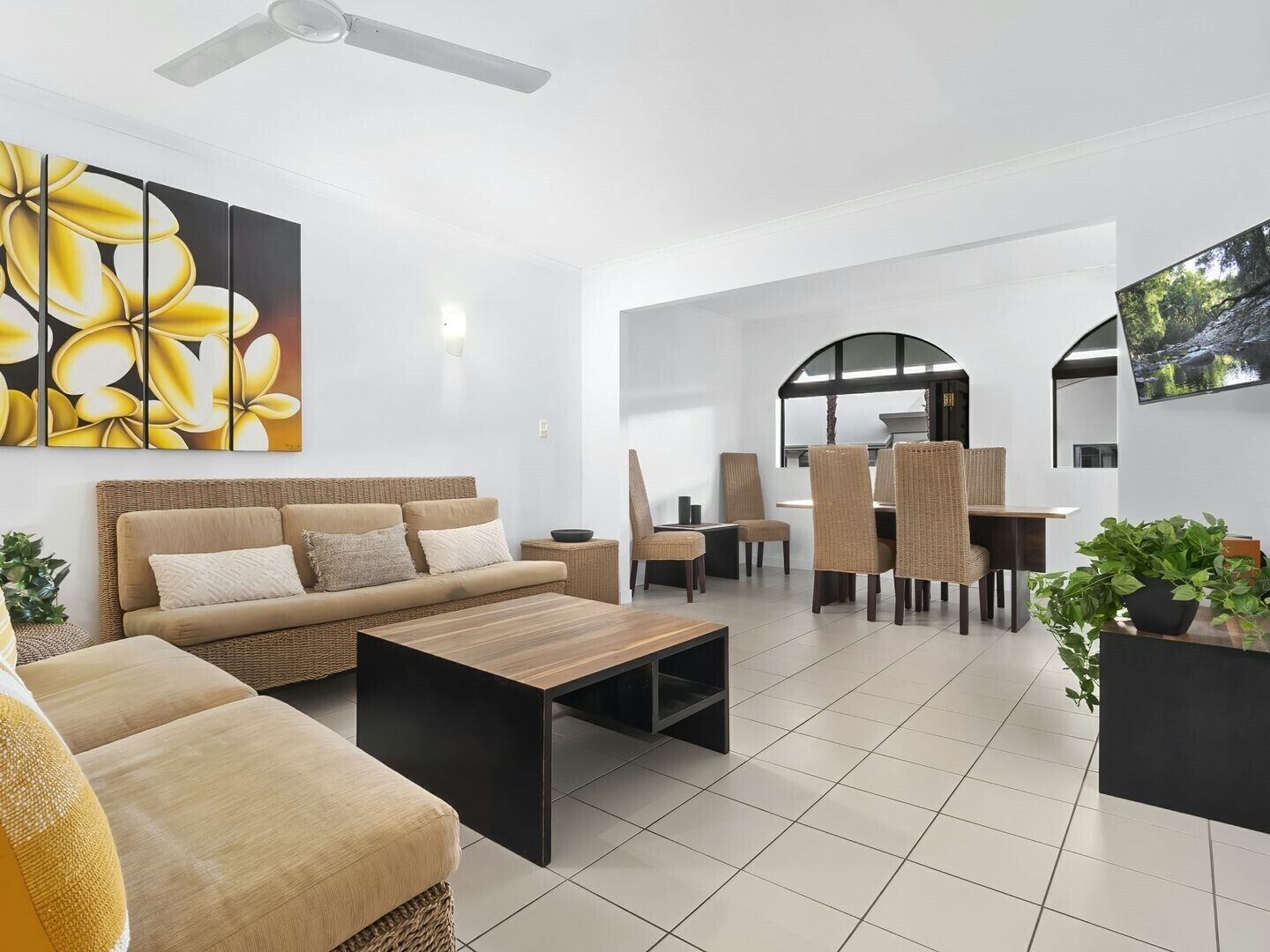 Uma sala de estar moderna com sofá, mesa de centro e área de jantar com cadeiras.