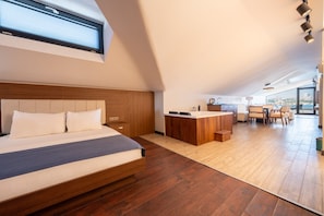 A modern bedroom with a large bed, a wooden headboard, a small bedside table, and a window with blinds. - 216 Bosphorus (Istanbul)