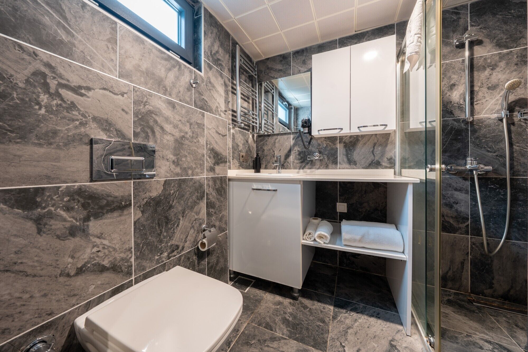 A modern bathroom with a bathtub, a glass-enclosed shower, and a vanity with a mirror.