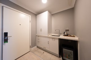 A compact kitchenette with a built-in refrigerator, a sink, and a coffee maker. - 216 Bosphorus (Istanbul)