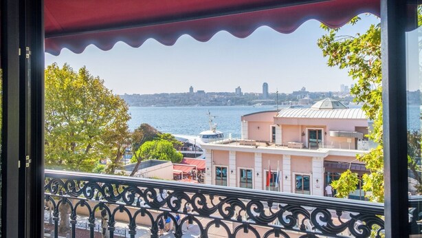 Ein Balkon mit Blick auf einen Fluss, Gebäude und eine Stadtsilhouette.