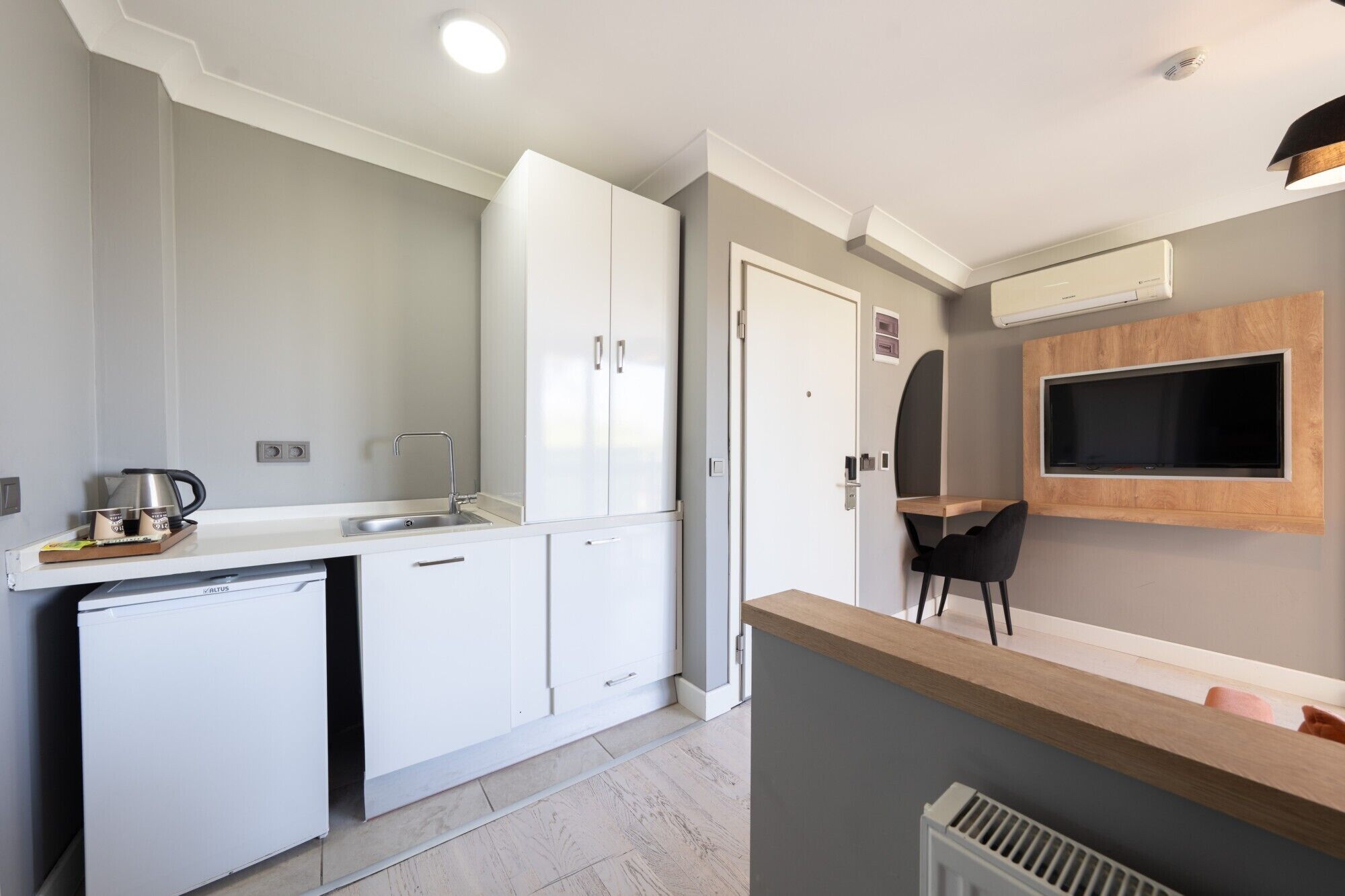 A compact kitchen with a built-in dishwasher, a sink, and a coffee maker.