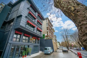 A multi-story building with balconies, a visible restaurant sign, and a parked car. - 216 Bosphorus (Istanbul)