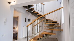 A modern staircase with wooden steps and metal railings, leading to a second floor. - Villa Cool with Private Pool (Malevizi)