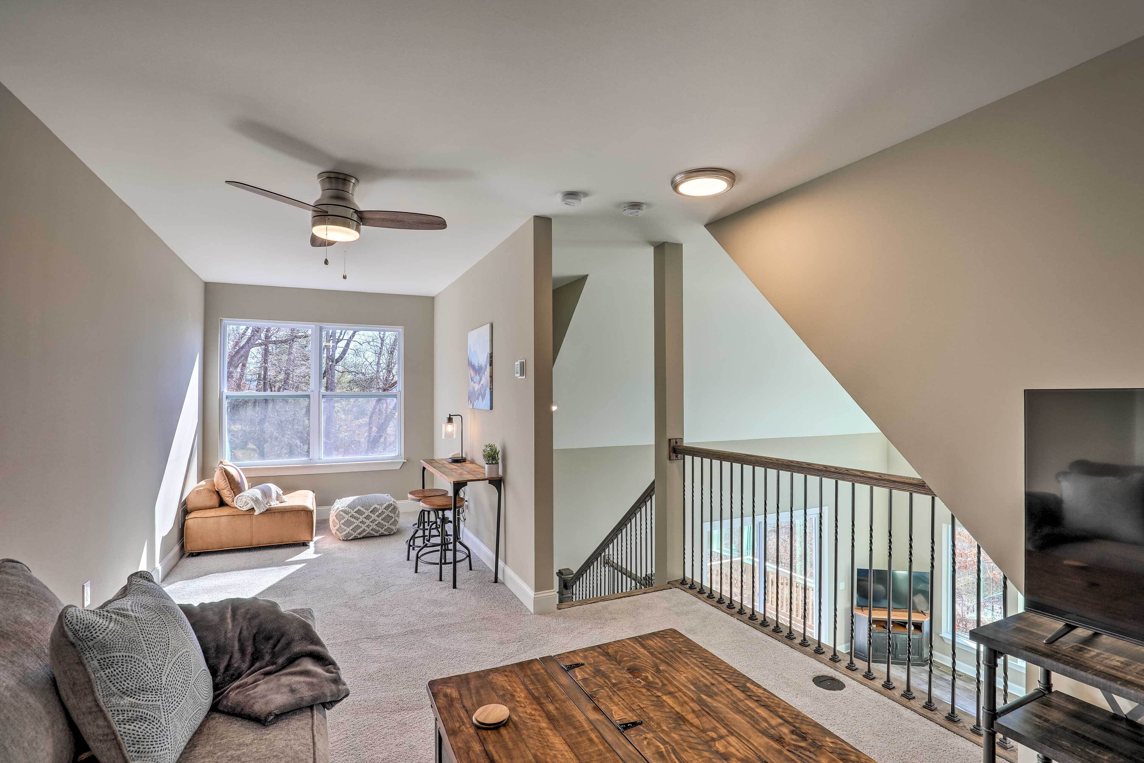 A spacious living area with a sofa, coffee table, and a staircase leading to an upper level.