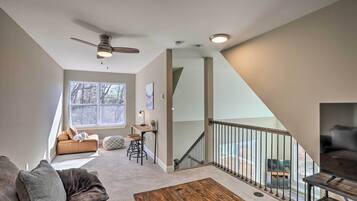 A spacious living area with a sofa, coffee table, and a staircase leading to an upper level.