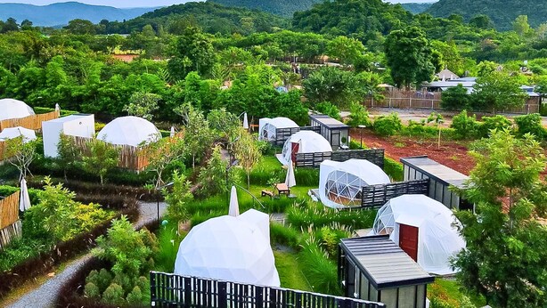 A series of dome-shaped cabins surrounded by lush greenery and hills in the background. - Glamping Hill Khaoyai (Pak Chong)