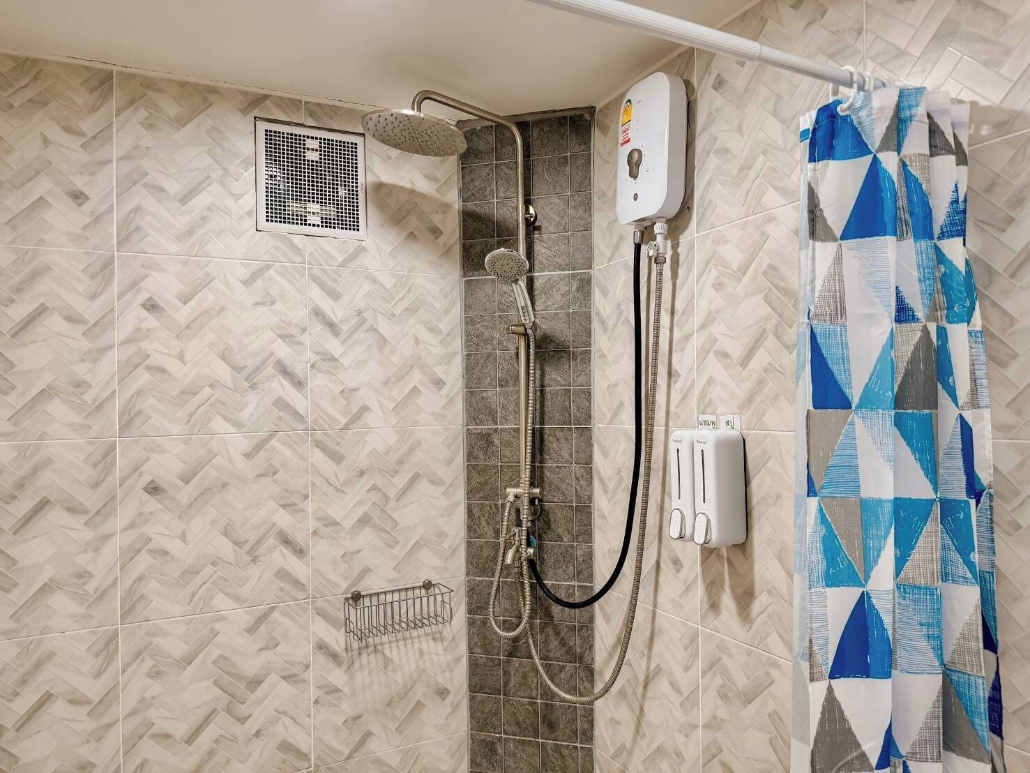 Een douchegedeelte met een regendouche, een handdouche en een handdoekhouder.
