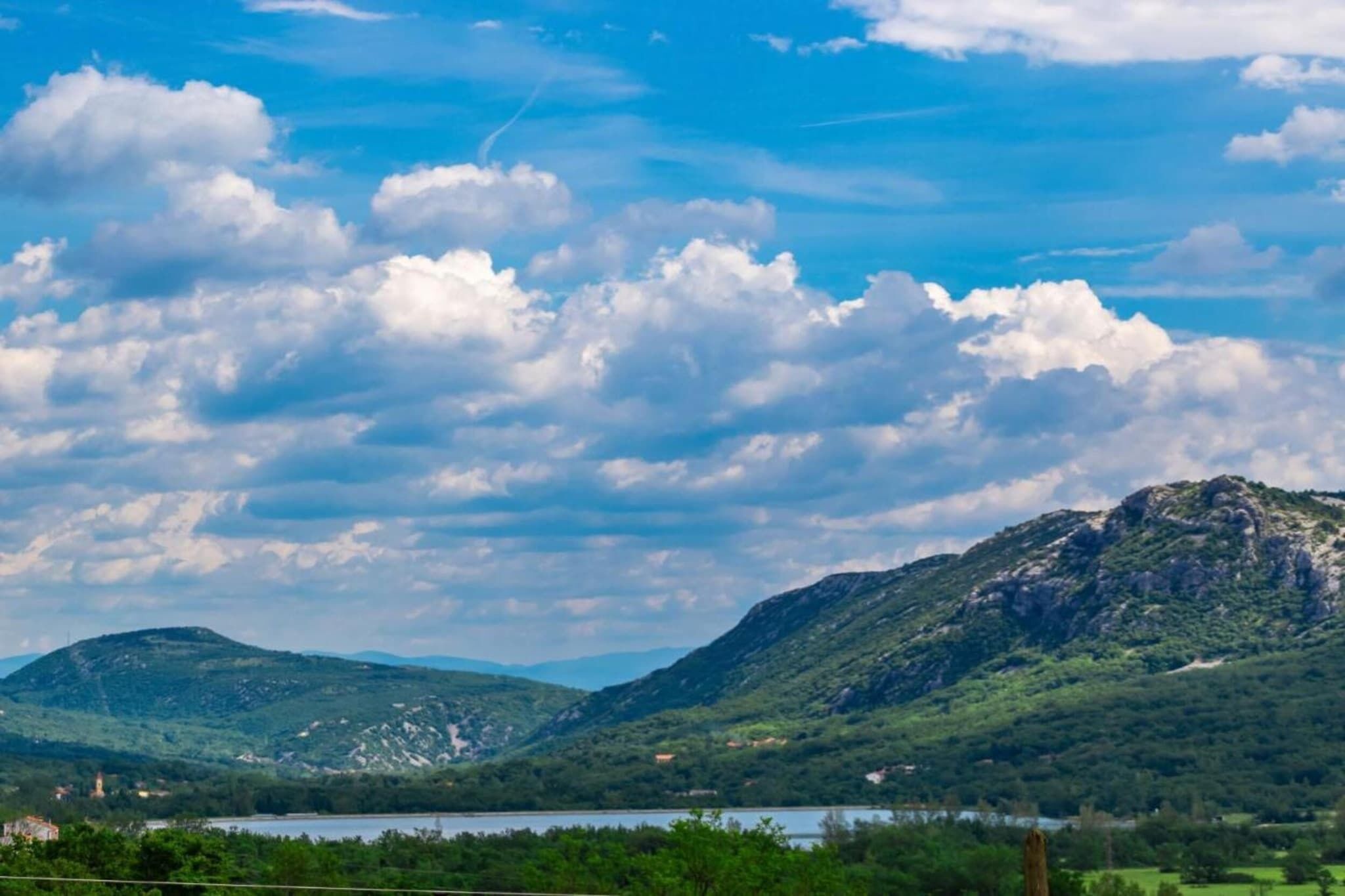 A mountainous landscape with a lake and a clear sky.