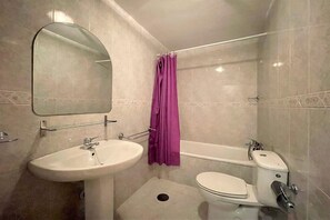 Ein Badezimmer mit Waschbecken, Toilette und Badewanne.