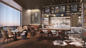 A modern cafe with a wooden ceiling, large windows, and a variety of seating options including chairs and tables. - Courtyard By Marriott Colombo (Colombo)