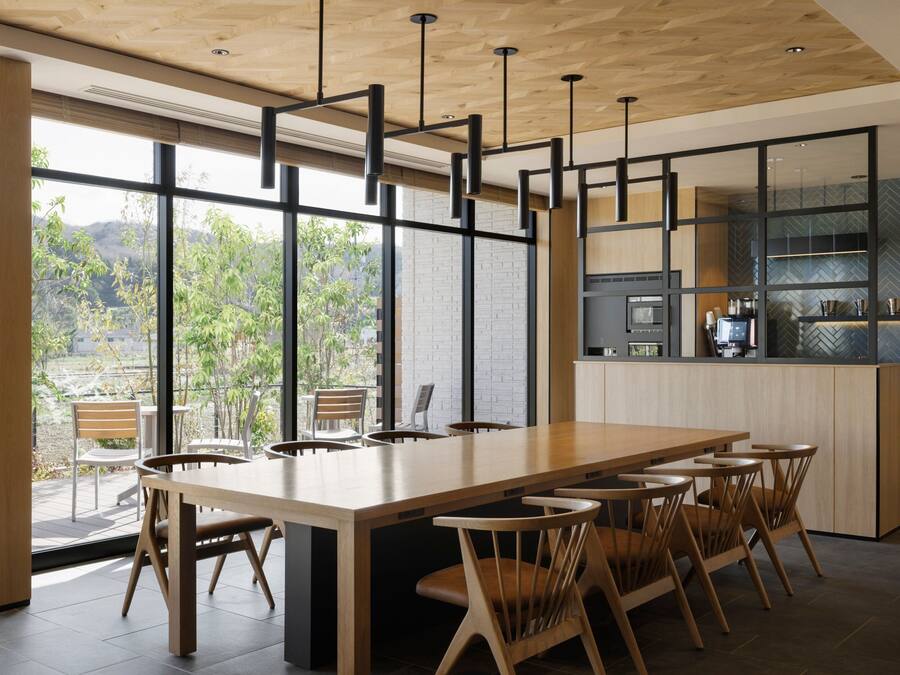 Una cocina moderna con una isla grande, electrodomésticos integrados y vistas a zonas verdes.