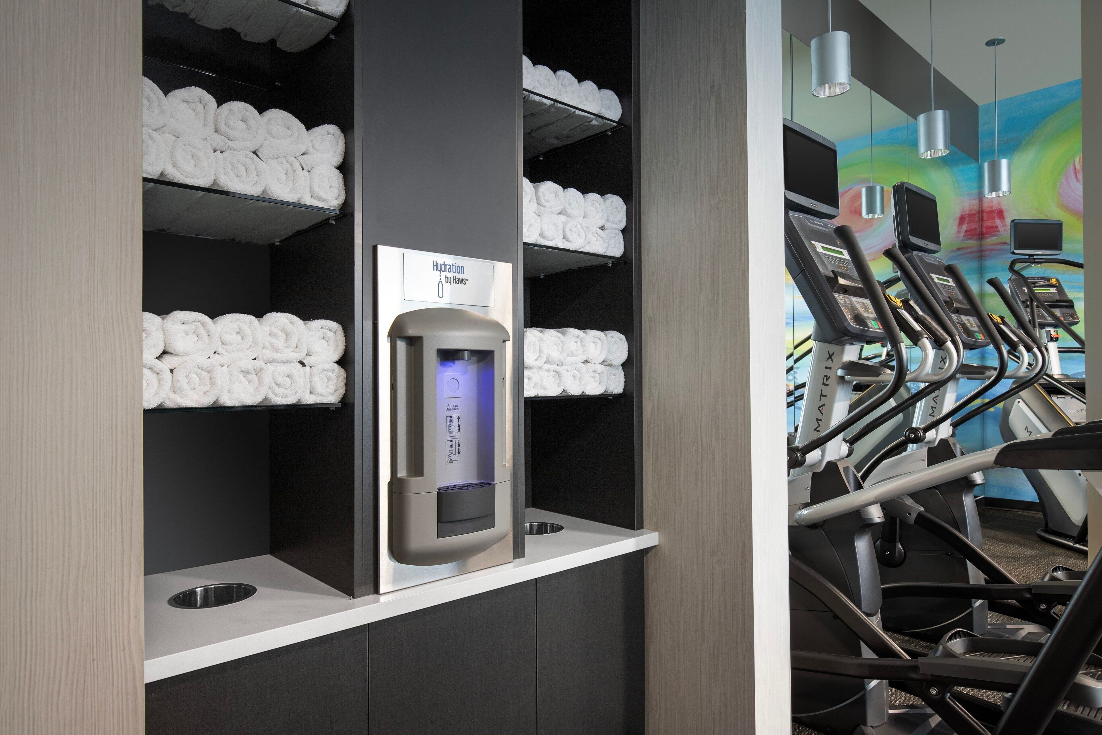 A gym area with exercise equipment and a hydration station.