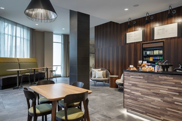 A modern restaurant with a wooden bar, seating area, and menu boards.
