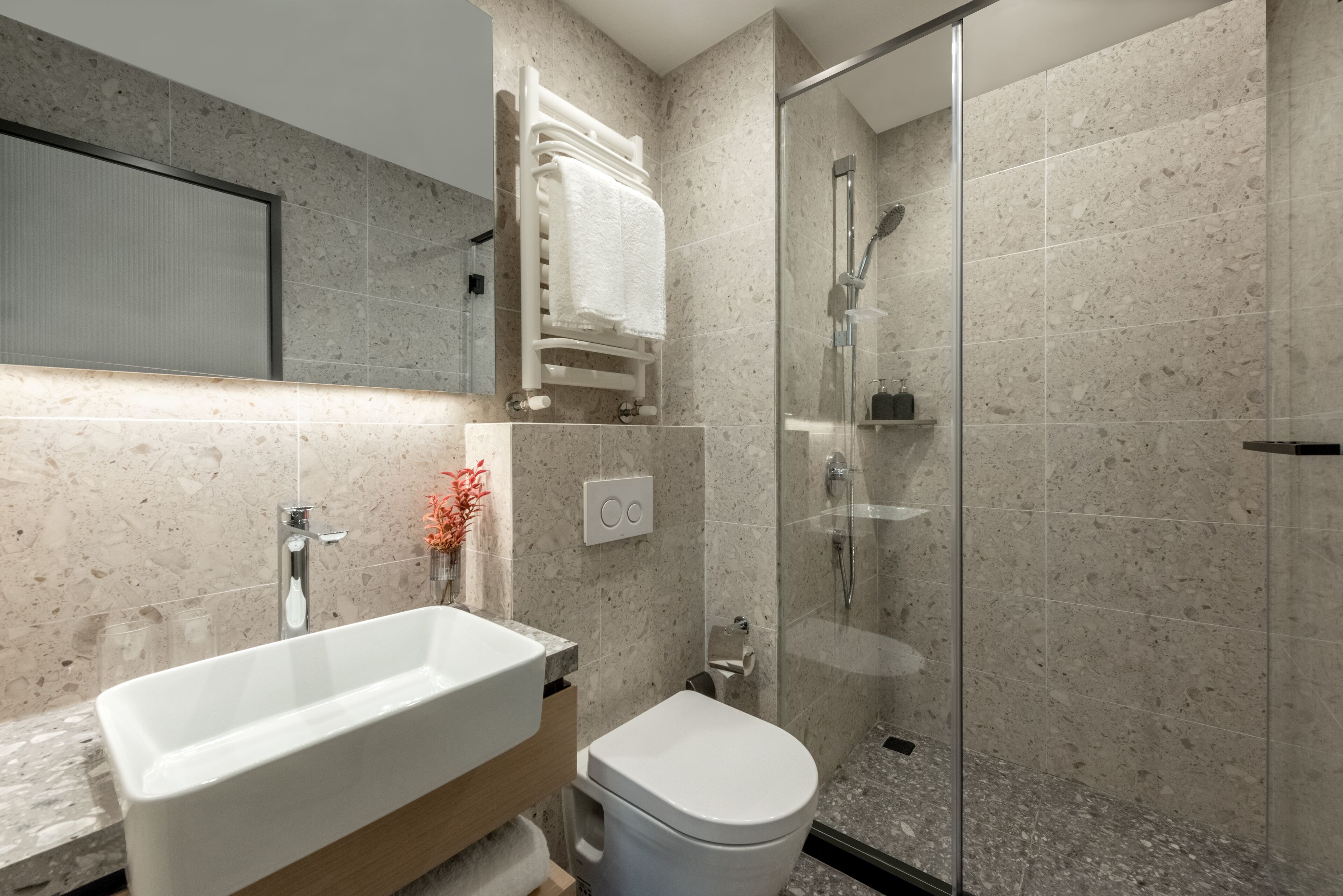 A modern bathroom with a freestanding bathtub, a toilet, and a glass-enclosed shower.