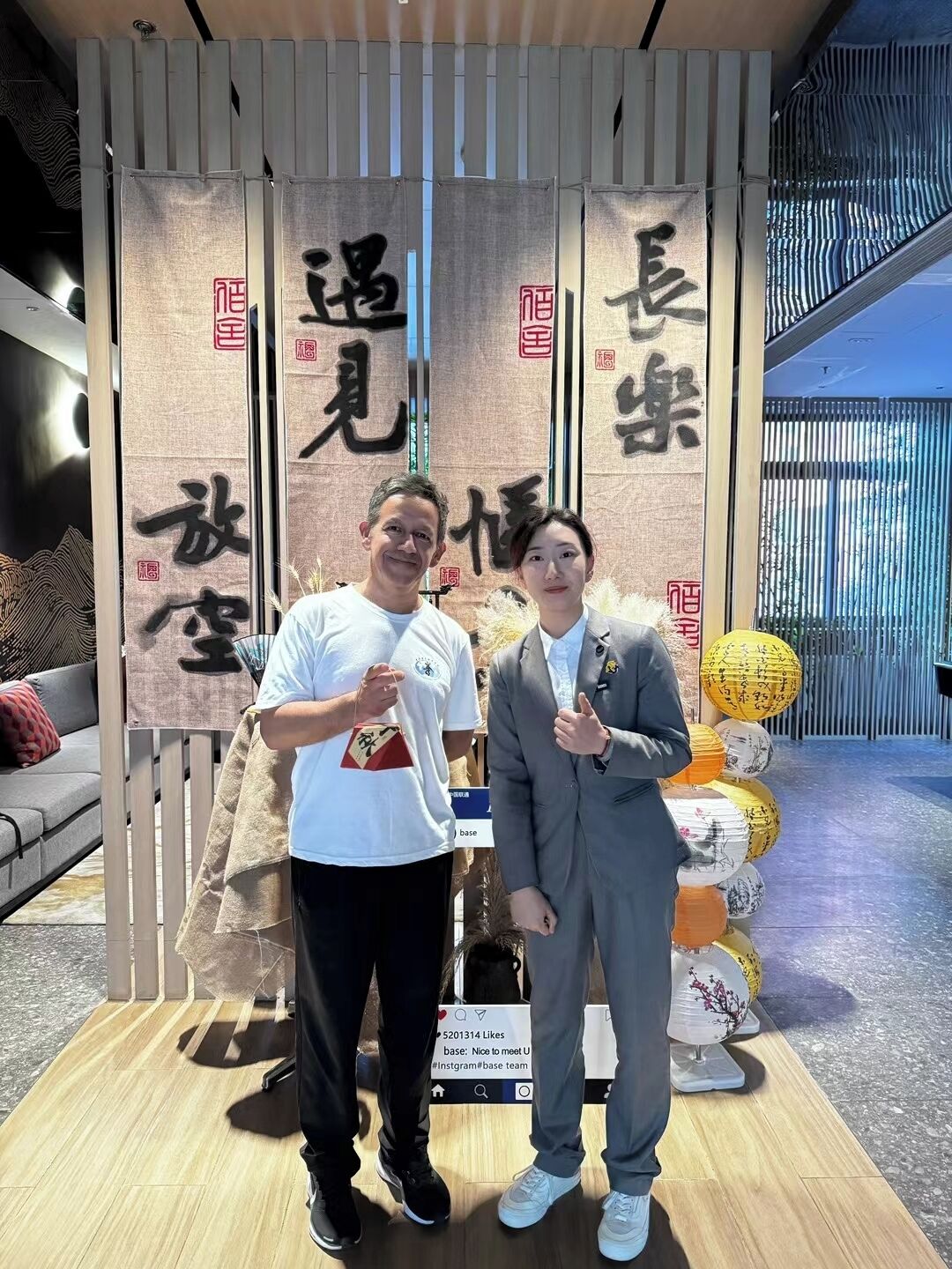 Zwei Personen stehen vor einer Vitrine mit vertikalen Tafeln, die chinesische Schriftzeichen zeigen.