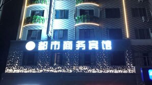Un immeuble doté de balcons et d’une enseigne indiquant « Hôtel commercial de Shenzhen ».