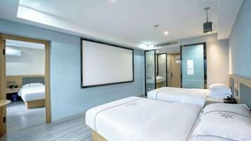 A modern hotel room with two beds, a large mirror, and a flat-screen TV.