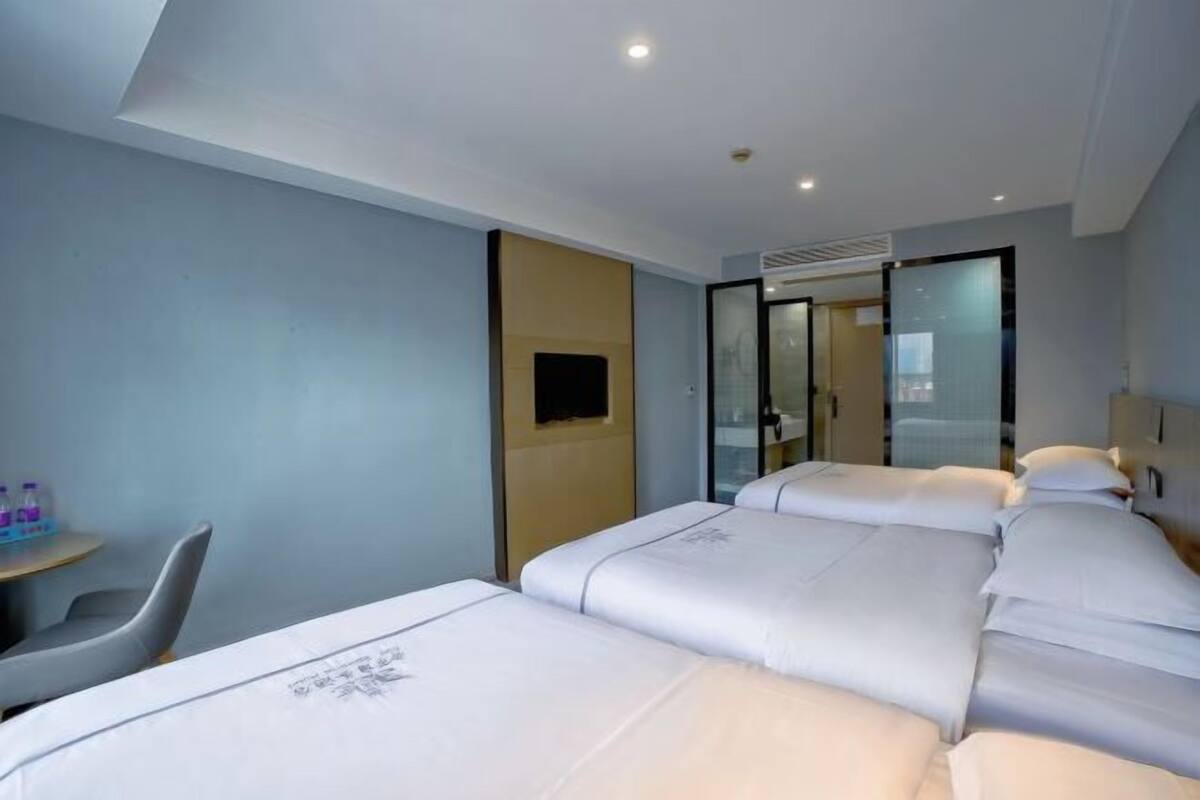 A hotel room with two beds, a desk, and a chair.