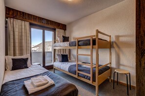 A room with a bunk bed, a single bed, and a small stool. - Appartement Nevada 105 - La Tzoumaz, 4 Vallees (La Tzoumaz)