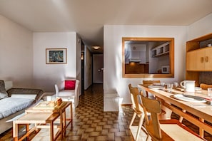 Um espaço compacto com área de jantar, cozinha compacta e cama.