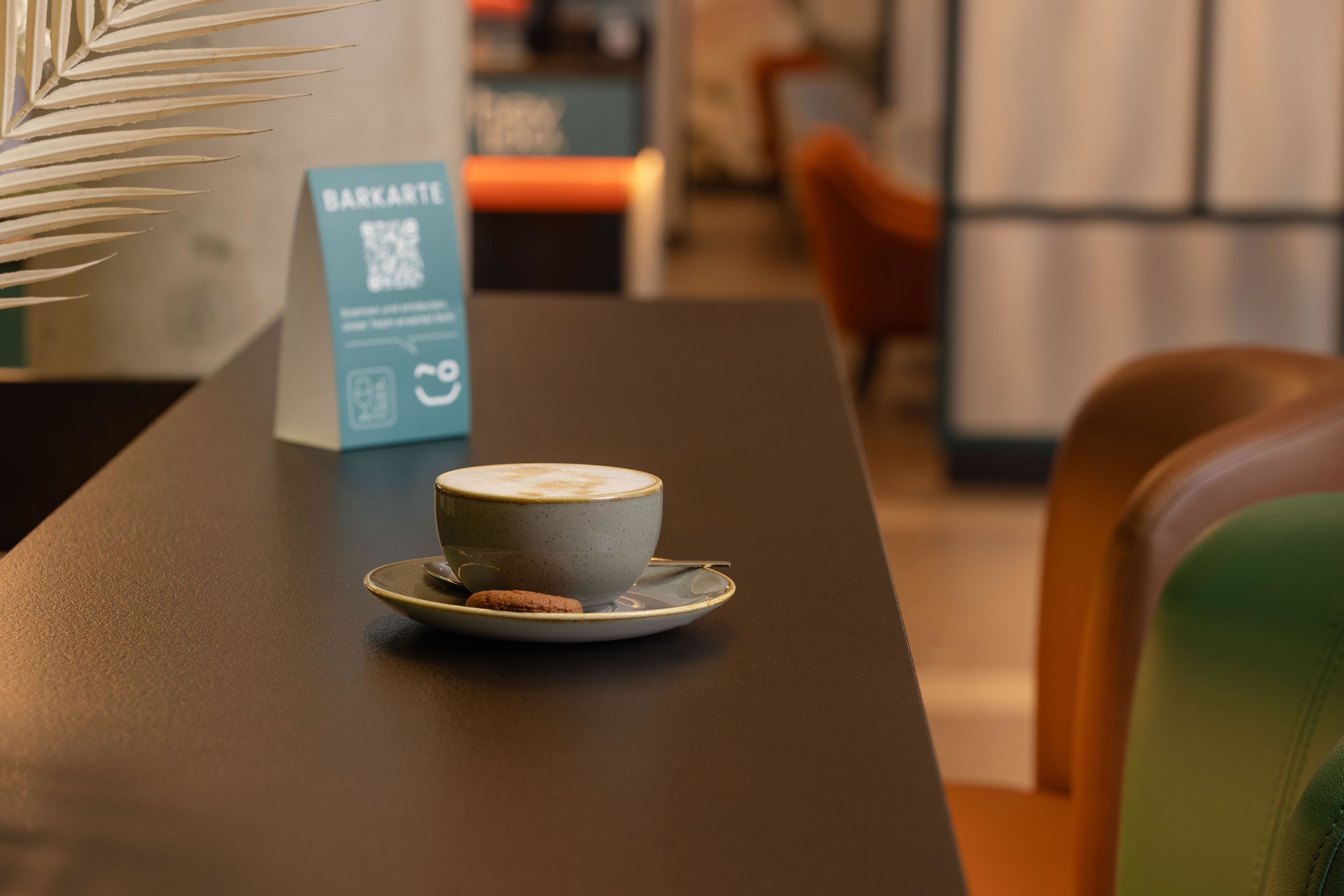 A table with a cup of coffee and a sign labeled 'BARKARTE'.