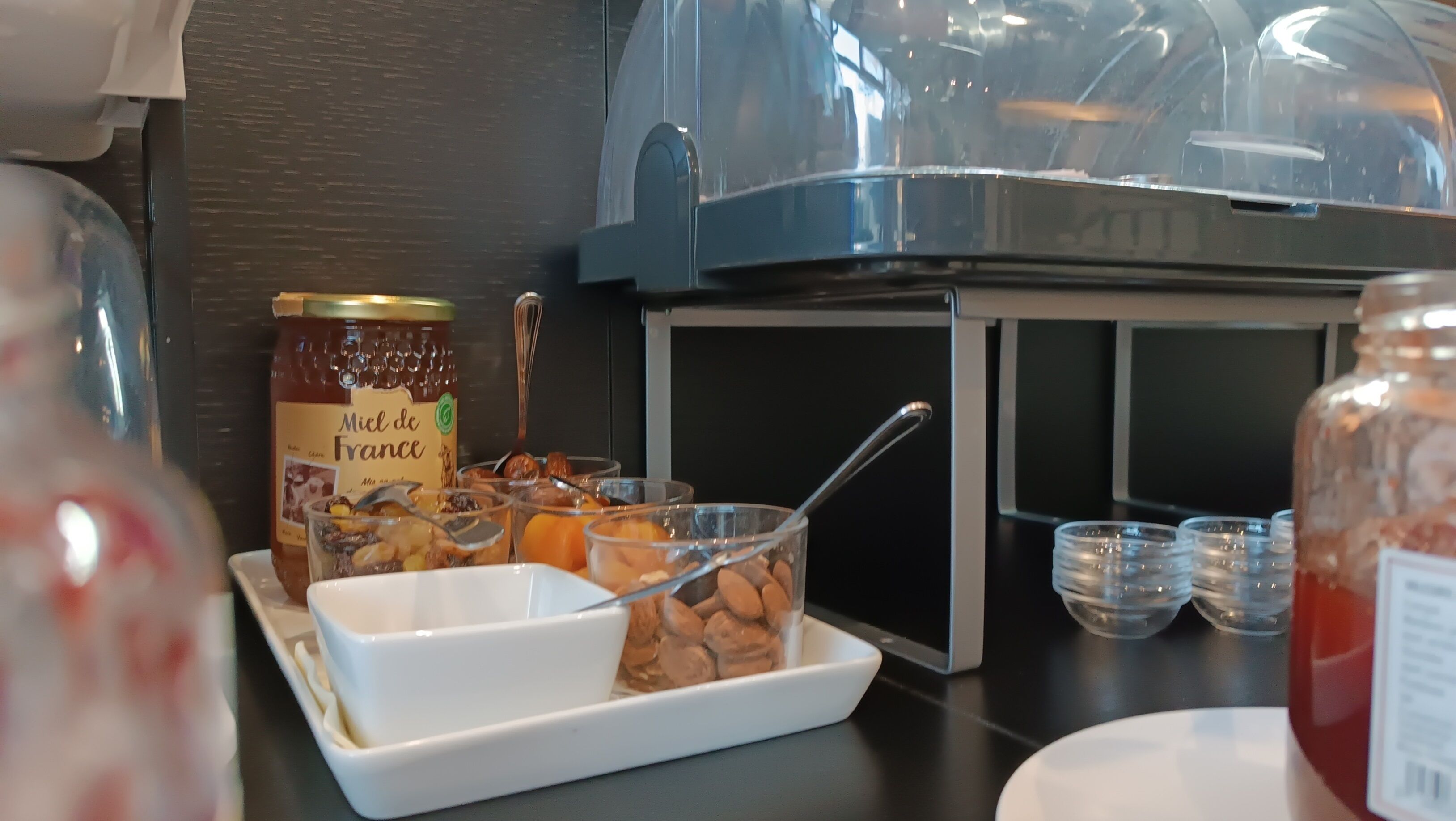A buffet setup with a variety of food items, including a jar labeled 'Miel de France'.