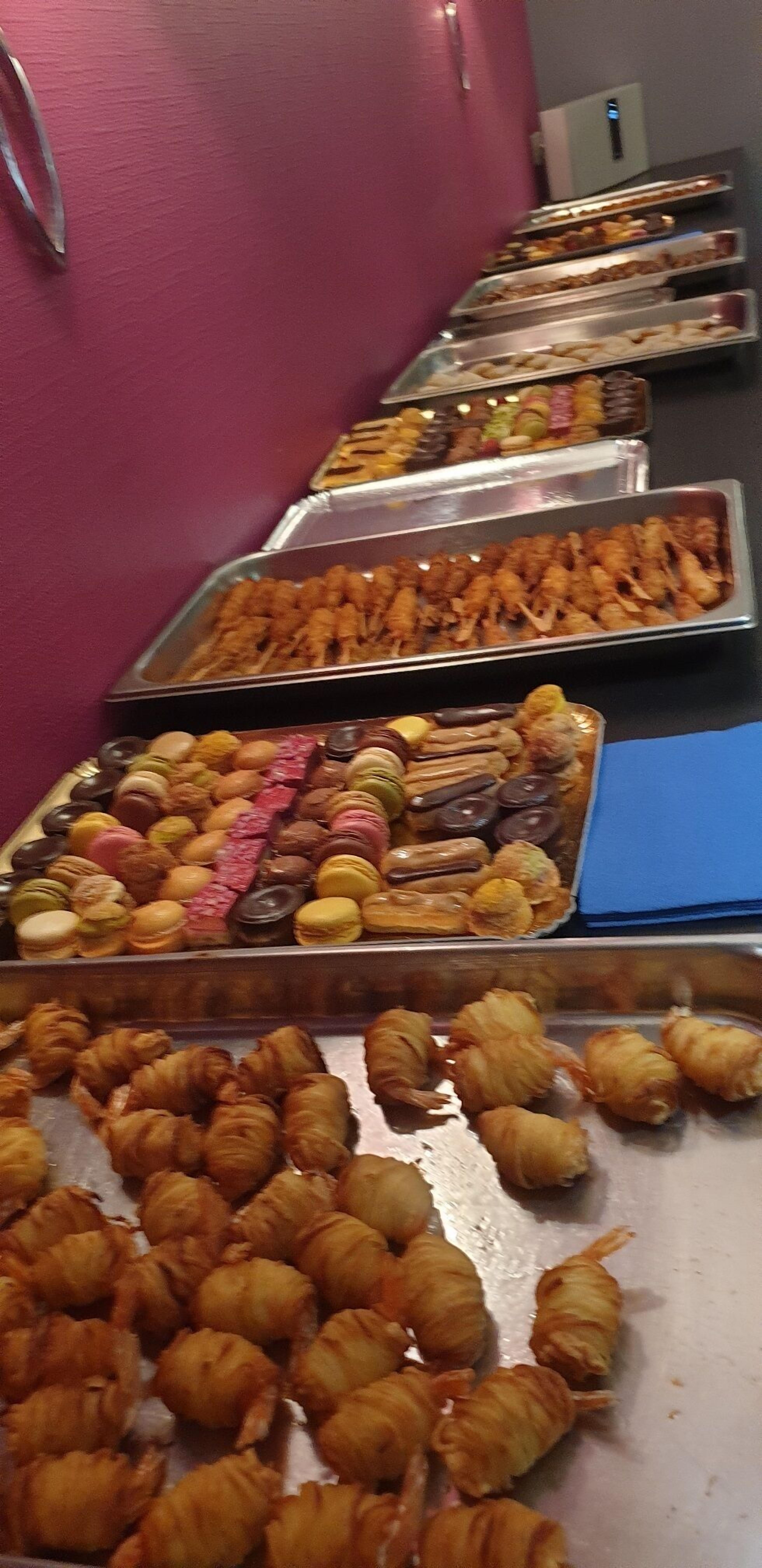 A buffet with various food items including pastries and desserts.