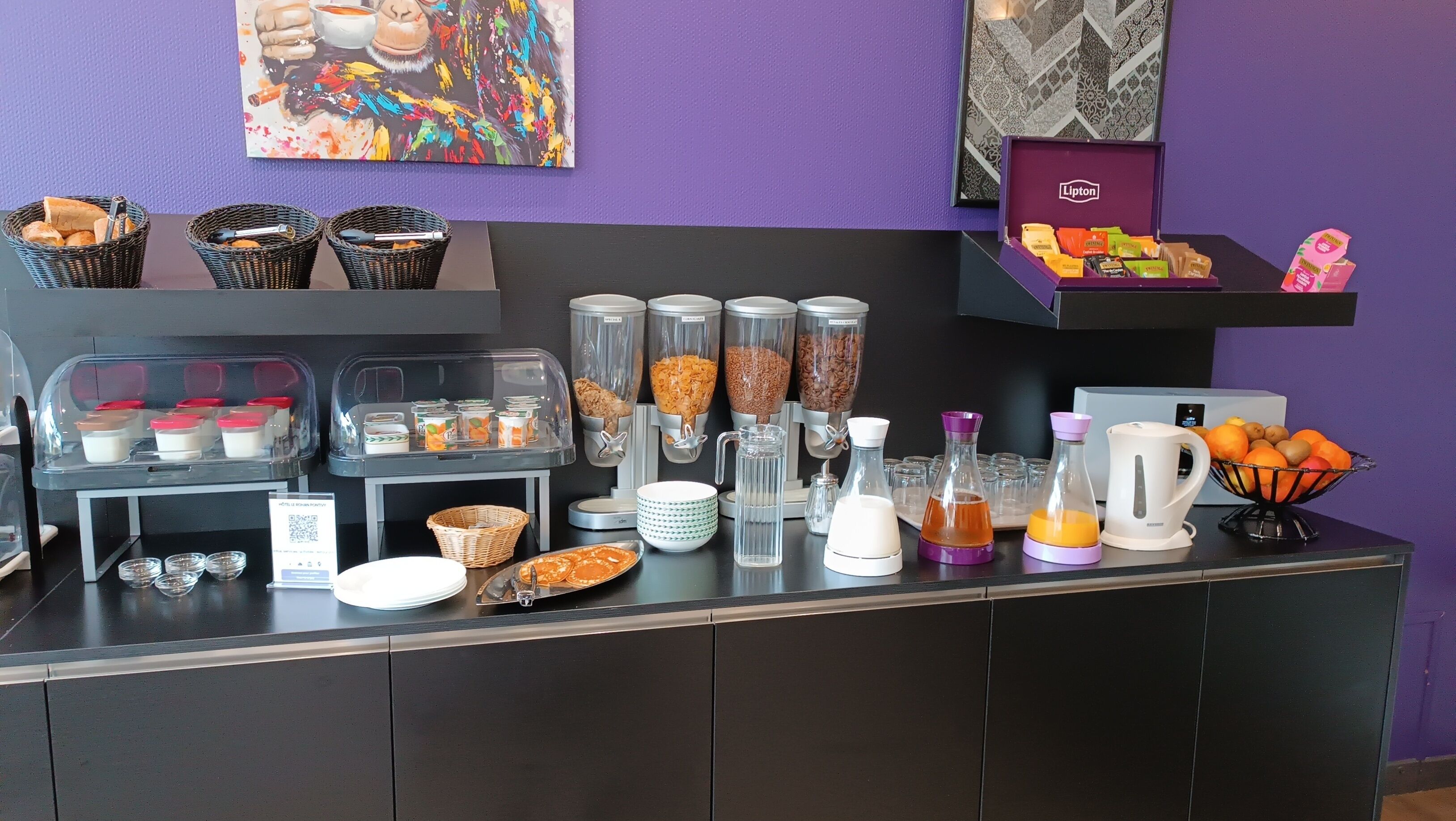 Un buffet de petit-déjeuner proposant une variété d’aliments et de boissons, notamment des céréales, des fruits et du café.