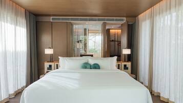 Una habitación de hotel moderna con una cama grande, dos mesitas de noche y un espejo grande sobre la cama.
