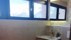 A compact bathroom with a window, a sink, and a toilet. - Courchevel 1550 Village 5-person apartment (Courchevel)