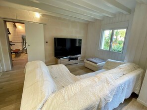 A bedroom with a bed, a TV, and a window.