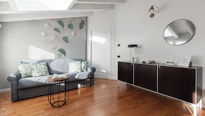 A modern living room with a grey sofa, a round coffee table, and a dark wooden cabinet. - Italianway Comfort - Rubens 19 B (Milan)