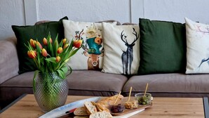 A dining area with a wooden table, a vase of tulips, and a plate of food.