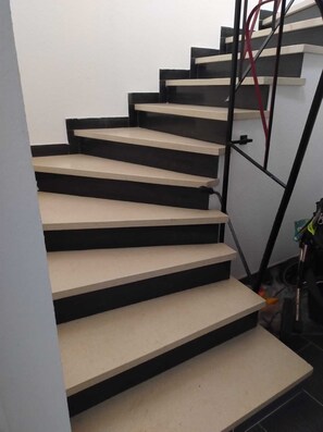 A staircase with alternating black and beige steps, leading to a landing. - Großzügige Ferienwohnung in Heßheim (Heßheim)