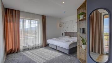 Una habitación de hotel moderna con una cama grande, un estante empotrado con plantas y vistas a través de la ventana.