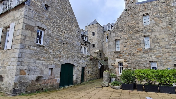 A stone building with multiple windows and a green door. - Seaside in Roscoff, studio for 2 people, sea view, close to shops, beach (Roscoff)