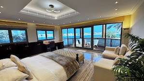 A modern hotel room with a large bed, a desk, and a balcony with a view of the sea. - Sparking signature Beach front villa reverera mediterian style in Palm Jumeirah  (Dubai)
