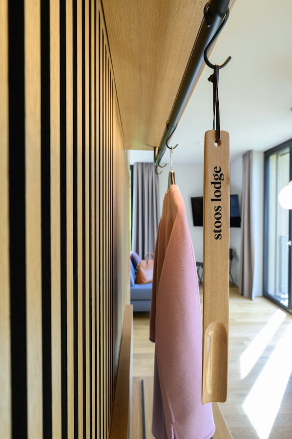 Un perchero de madera con una etiqueta que dice "stoo's lodge" en un ambiente interior moderno.