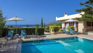 Piscine extérieure, parasols de plage, chaises longues