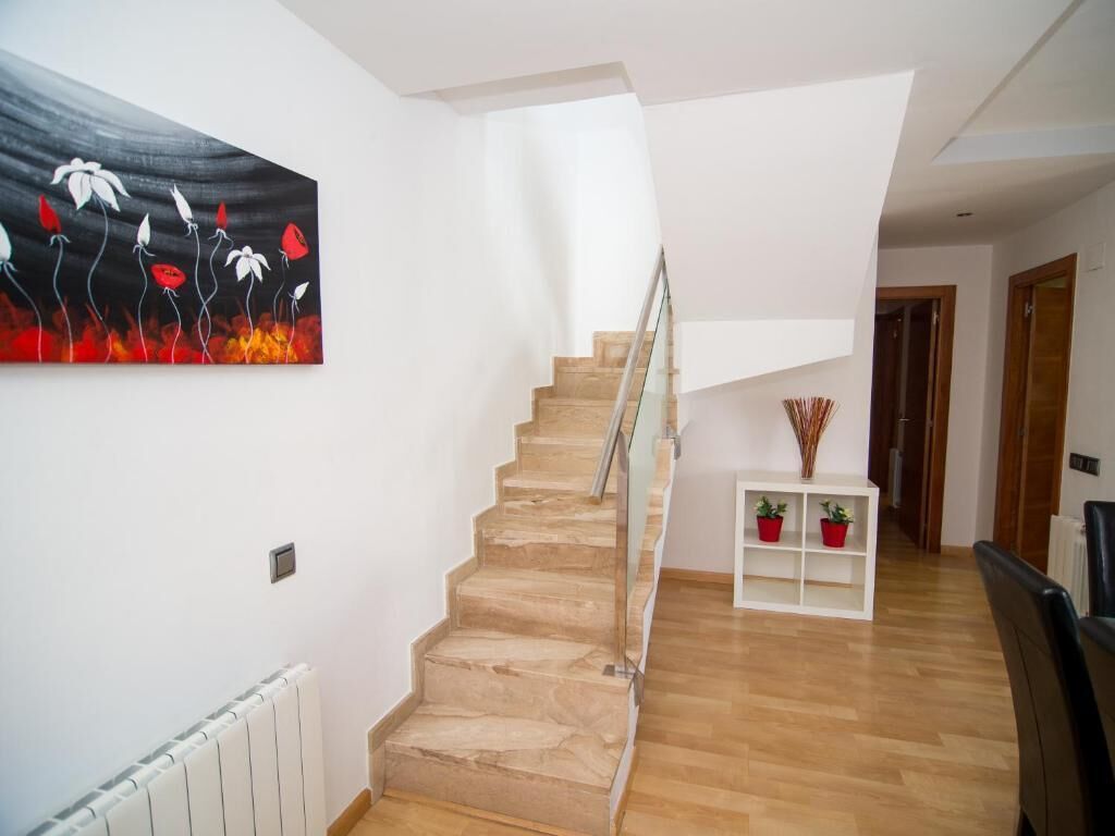 A staircase with a glass railing leading to a landing.