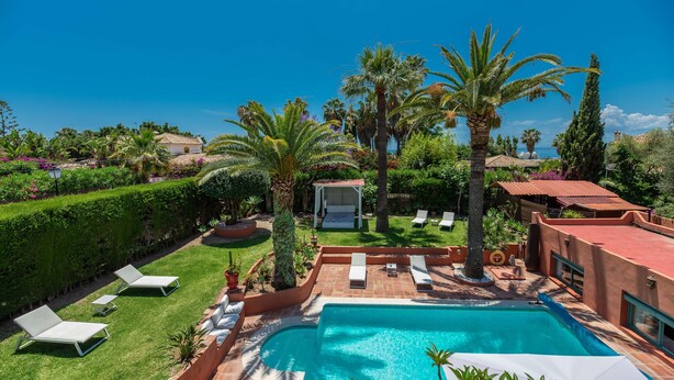 A swimming pool with lounge chairs, palm trees, and a view of the sea. - 'Villa Tiphareth' with Private Pool, Wi-Fi and Air Conditioning (Marbella)