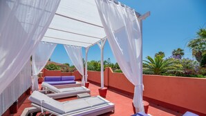 A rooftop terrace with white sunbeds, a red wall, and a clear blue sky. - 'Villa Tiphareth' with Private Pool, Wi-Fi and Air Conditioning (Marbella)