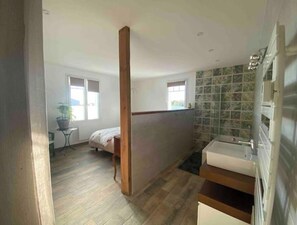 A bedroom with a wooden ceiling beam, a bed, a small table with a plant, and a window. - Sea view, 5 minutes from Chatelaillon beach... a lovely family home. (Yves)