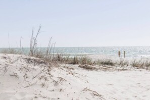 Een strand met duinen en een helder uitzicht op de oceaan.