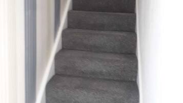 Ein Teppichgesteiger mit Handlauf, der zu einer oberen Etage führt.