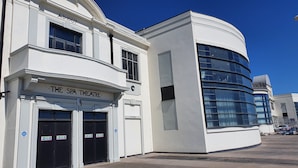 Un edificio con un cartel que dice "THE SPA THEATRE" y un cartel que indica "PIT EXIT".