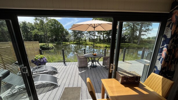 A deck with outdoor furniture, a table, and a wicker basket. - Cedar Boutique Lodge-dog, Fishing and Spa Access (York)