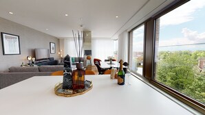 Un salon moderne avec un coin repas, de grandes fenêtres et une vue sur la ville.