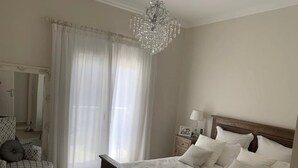 Una camera da letto con un letto grande, una testiera in legno, un comodino con una lampada e un lampadario.
